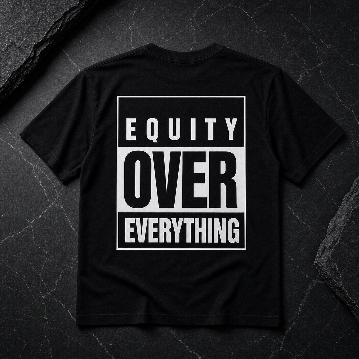 Equity Over Everything tee on neutral stone background